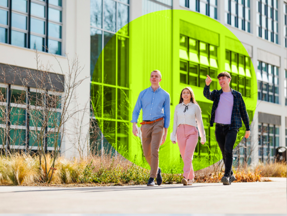 three people walking infront of a building smiling