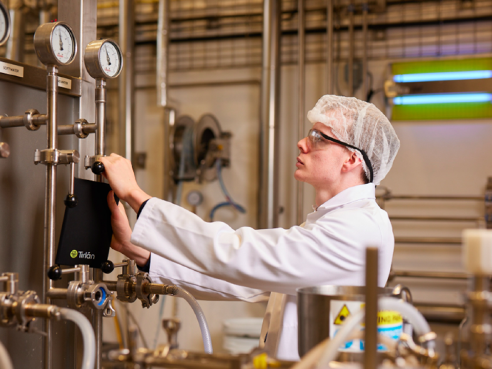 Man waering hair net and lab coat in a lab